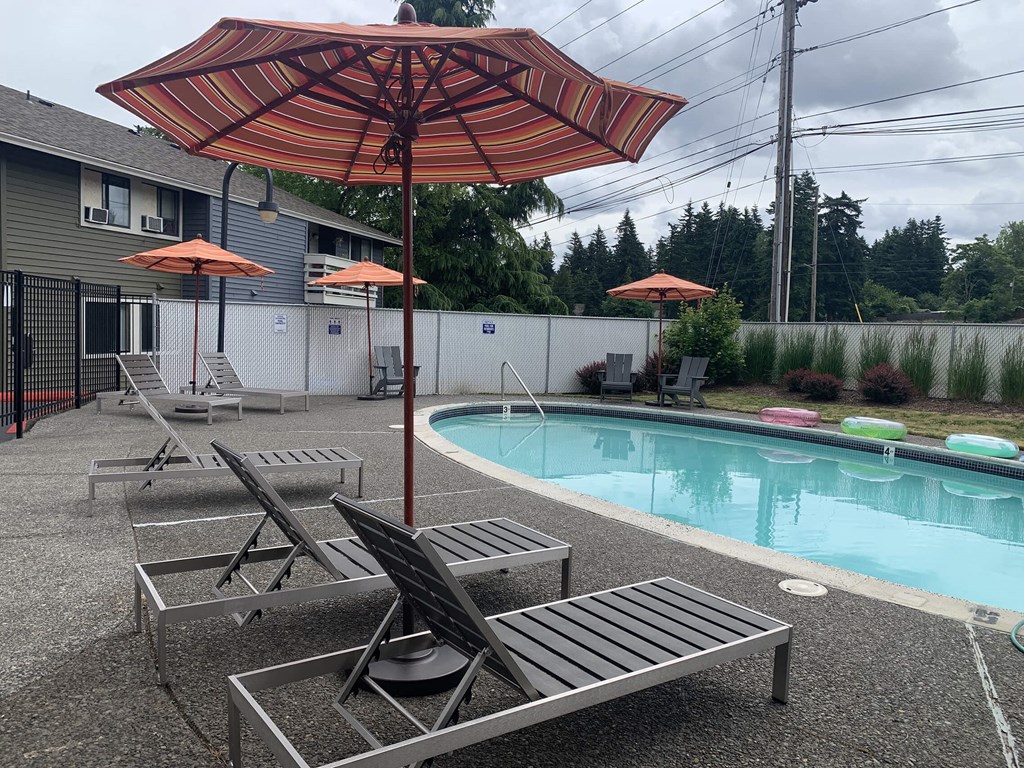 a pool with umbrellas and chairs next to a pool