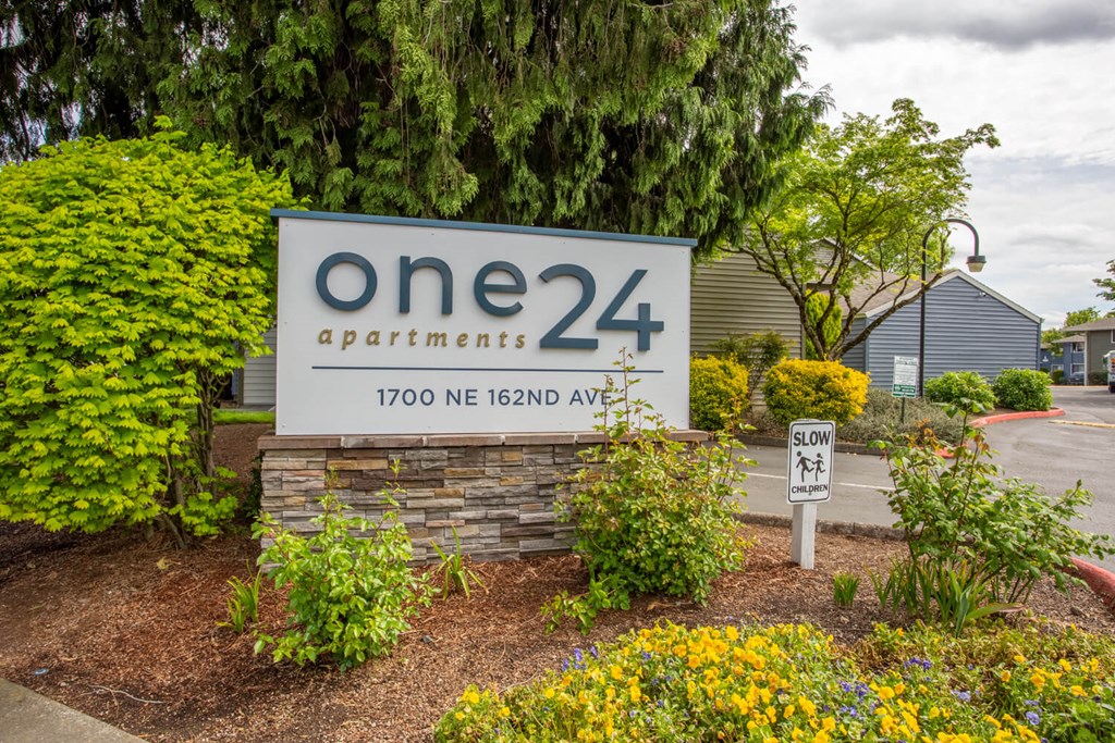 one 24 apartments sign in front of building with plants and trees