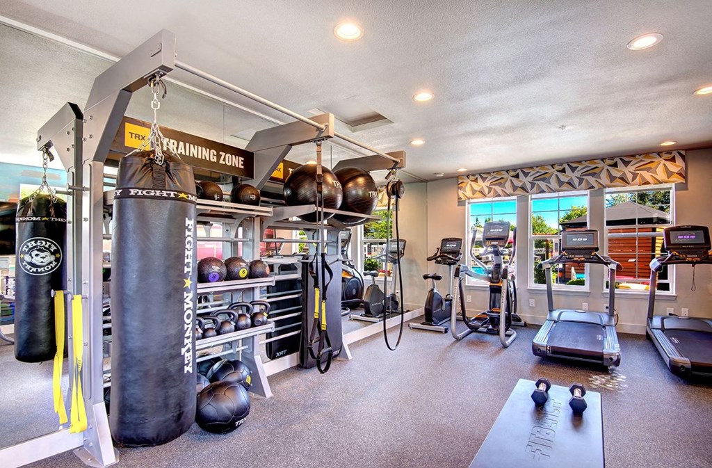 Resident Fitness Center With Treadmills, an Elliptical, a Punching Bag, and Handweights at Clock Tower Village, DuPont, WA