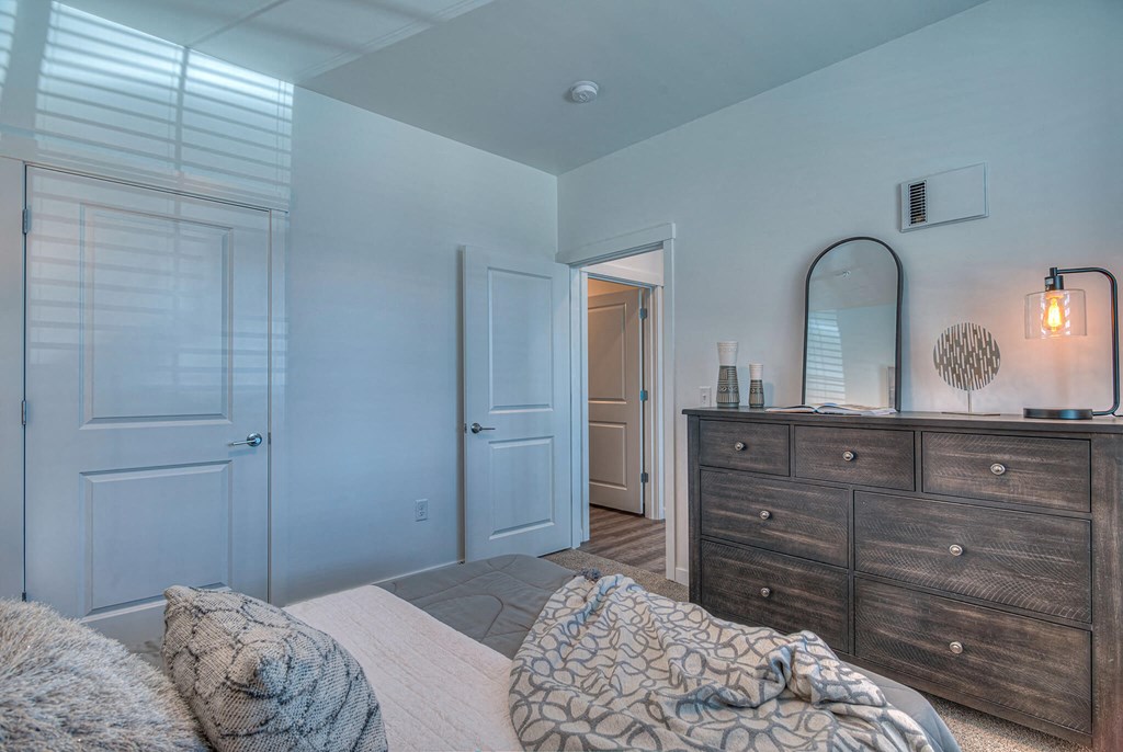 a bedroom with a bed and a dresser with a mirror