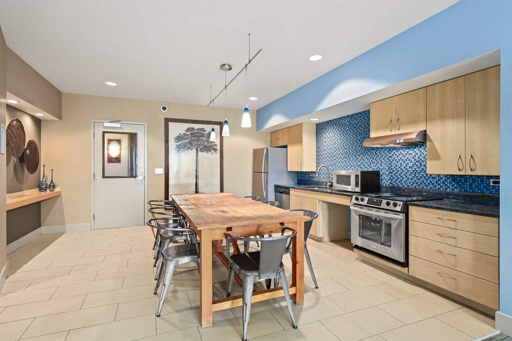 a kitchen with a wooden dining table and stainless steel appliances