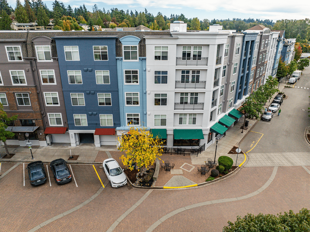 A parking lot with cars and apartment buildings in the background.
