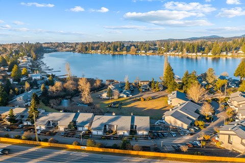 A view of a lake surrounded by houses and trees.