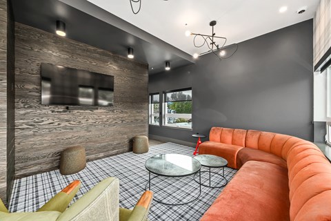 A modern living room with a curved orange sofa and a checkered floor.