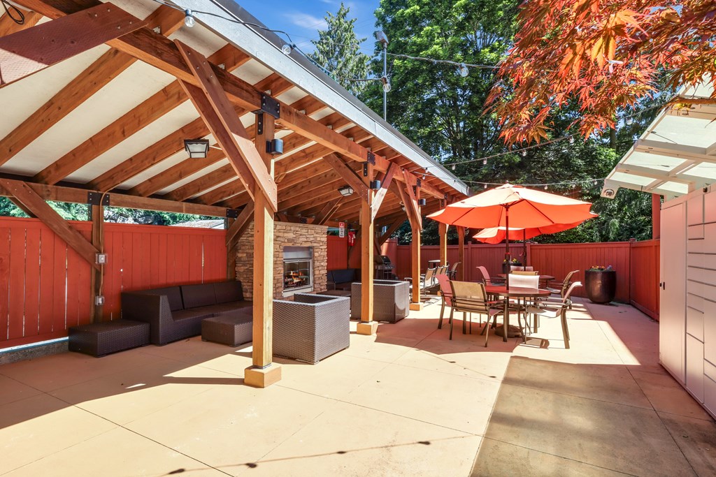 A patio with a table and chairs under a roof.
