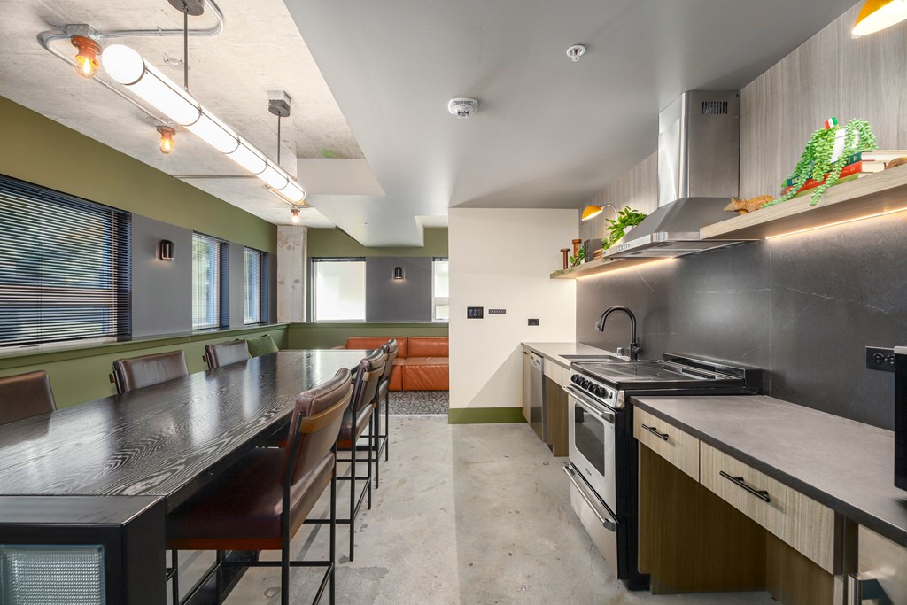 A modern kitchen with a long table and chairs.