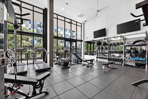 A gym with a variety of equipment including weights and machines.