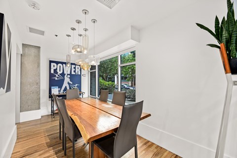 a dining room with a wooden table and chairs and a large window