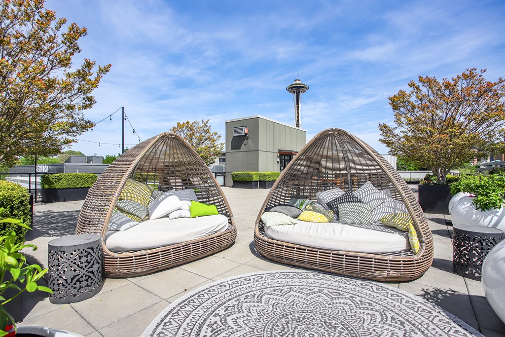 two egg shaped chairs with pillows on a rooftop patio