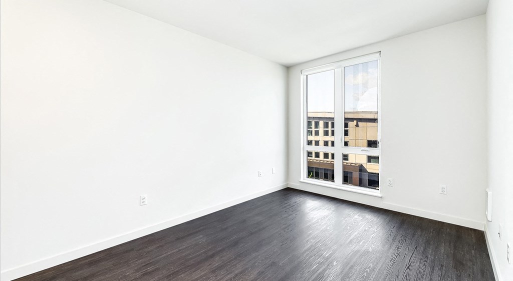 an empty room with wood floors and a window