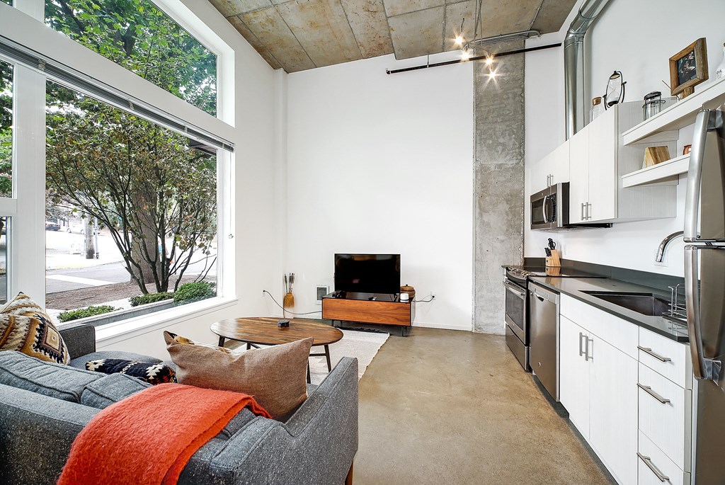 A living room with a grey couch and a fireplace.