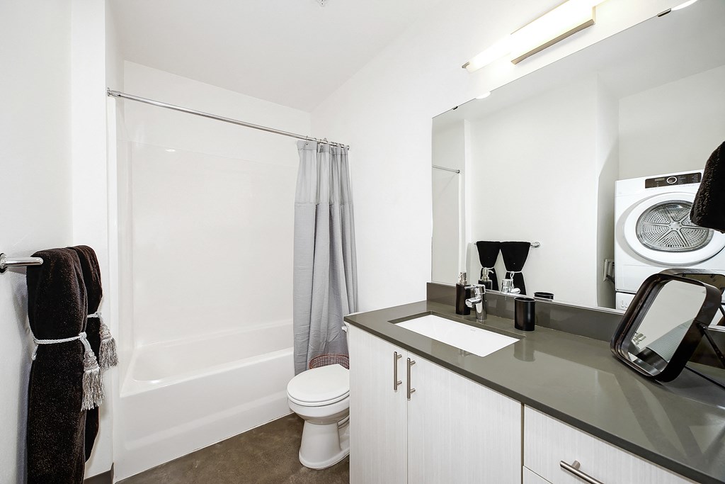 A bathroom with a toilet, sink, and mirror.