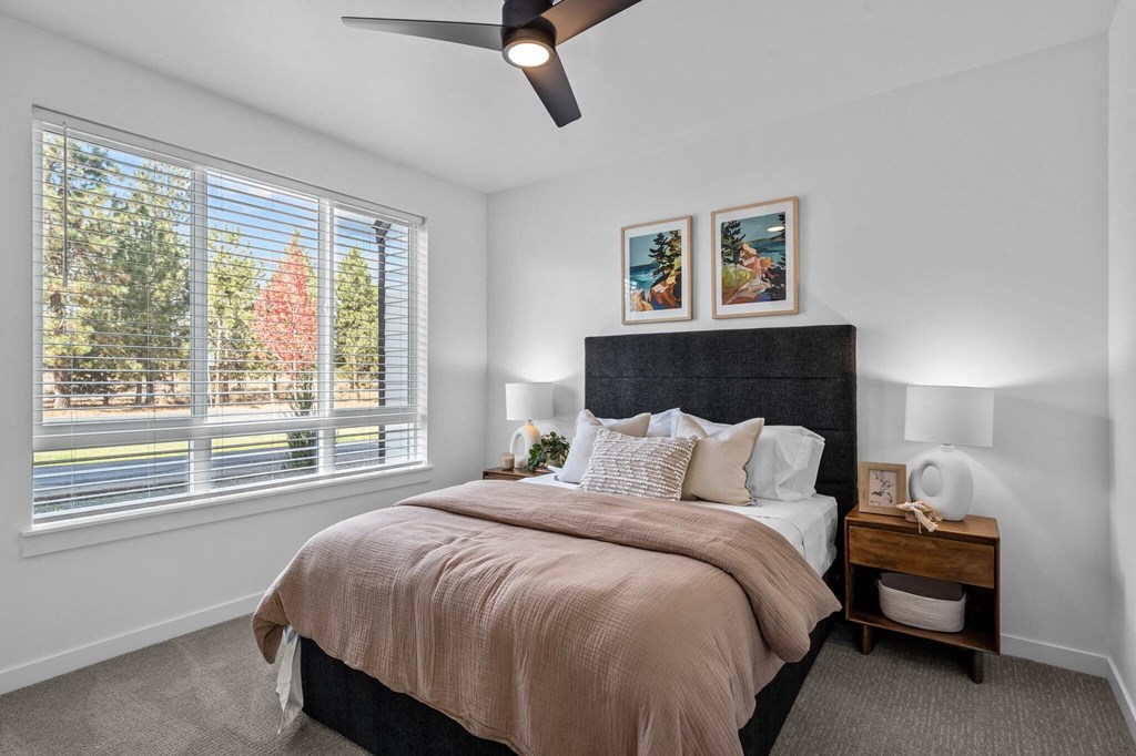 a bedroom with a large window and a bed