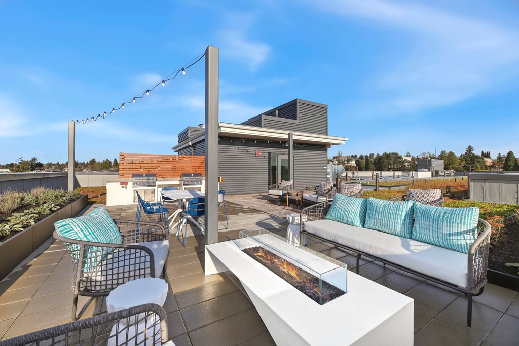 A patio with a white table and chairs with blue cushions.