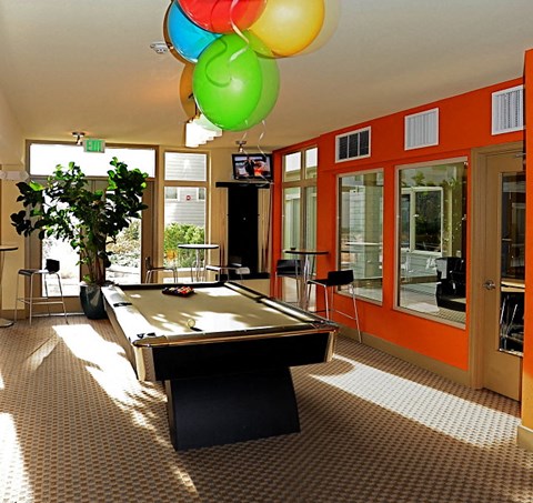 A pool table is in the middle of the room.