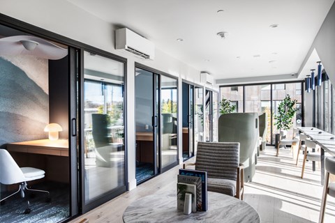 a lounge area with chairs and tables and sliding glass doors