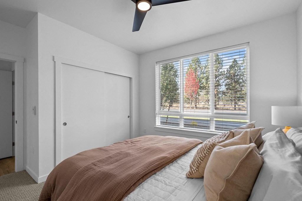 a bedroom with a large window and a bed