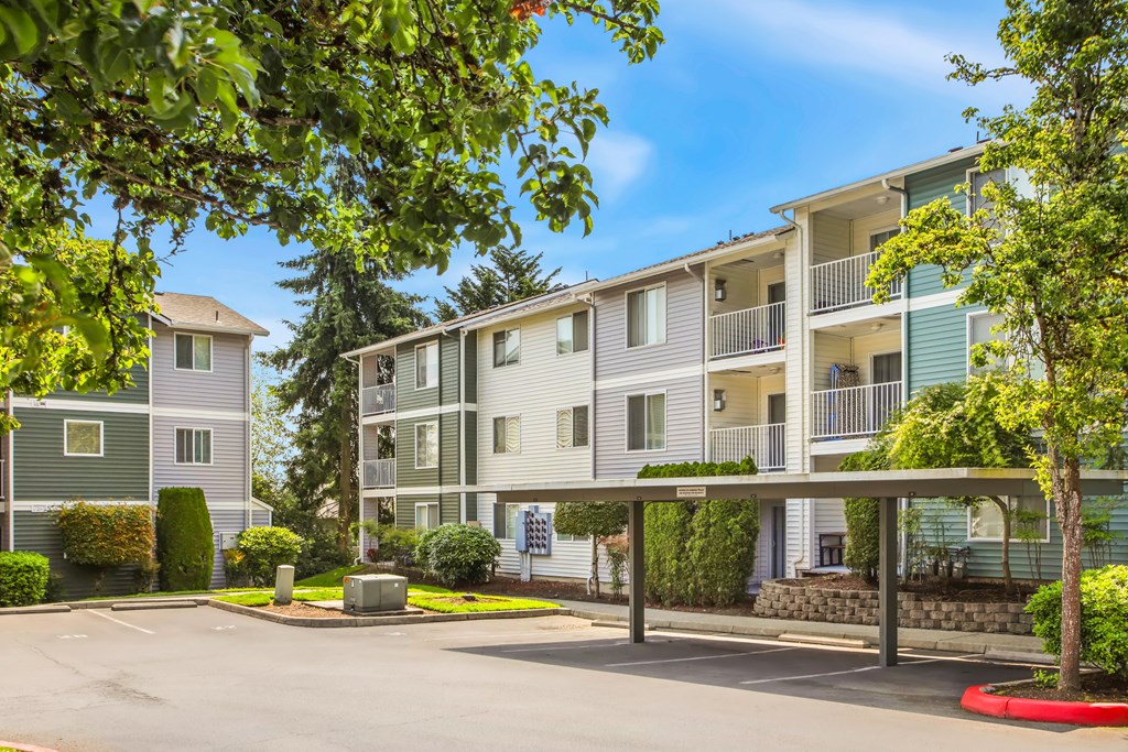 Apartment complex with green trees in front.
