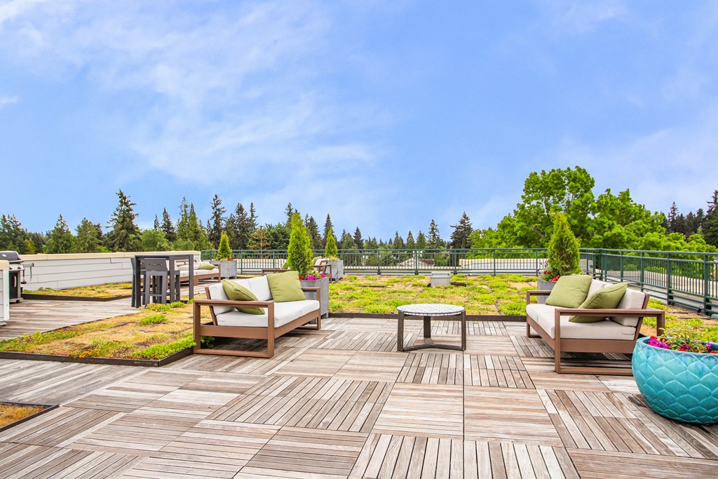 a deck with chairs and a table on top of a roof