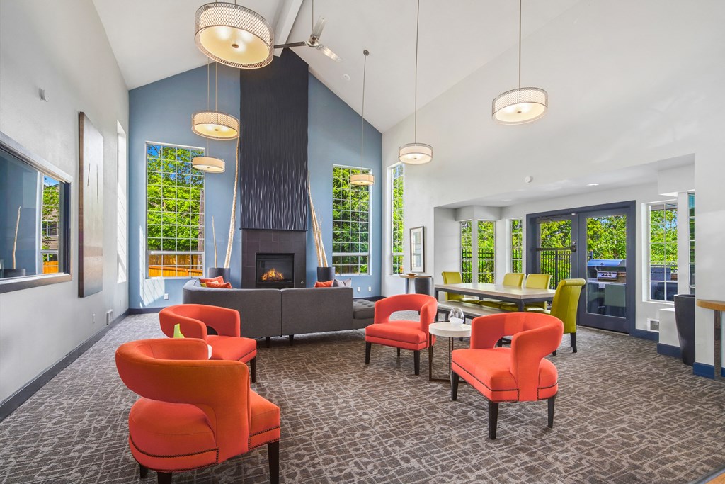 a lobby with chairs and tables and a fireplace