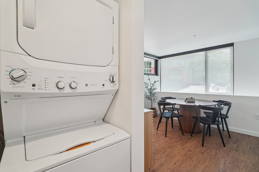 A white oven and dishwasher in a kitchen with a table and chairs.