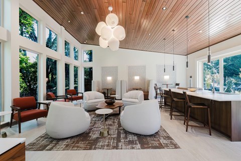 A modern living room with a wooden ceiling and white furniture.
