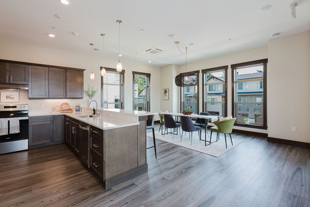 A modern kitchen with dark wood floors and a large island.