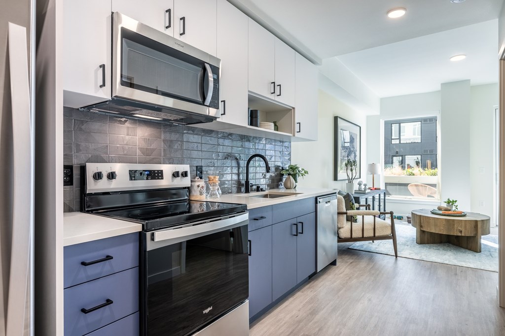 A modern kitchen with a stove top oven and microwave above it.
