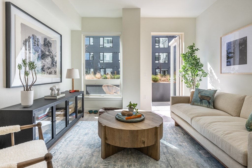 A living room with a couch, a coffee table, and a painting on the wall.