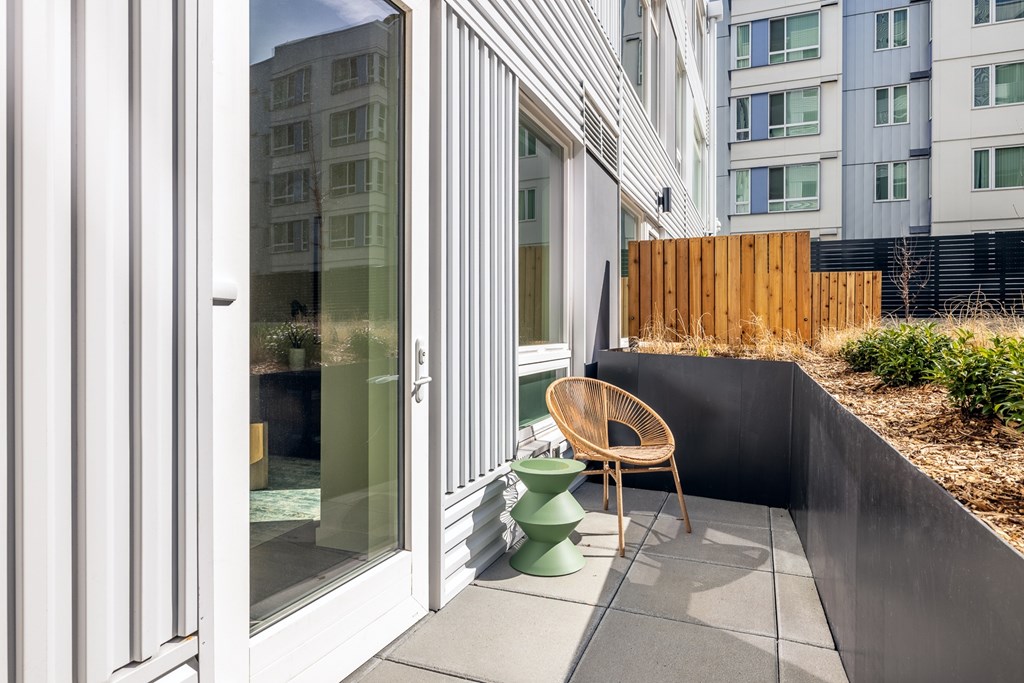 A patio with a chair and table outside a building.