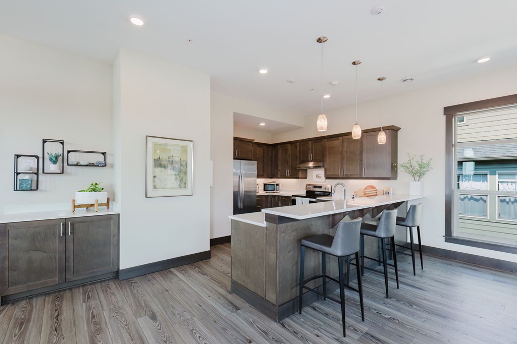 A modern kitchen with a bar area and a dining table.