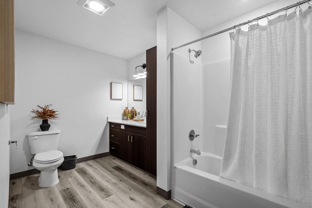 a bathroom with a shower and a toilet and a sink