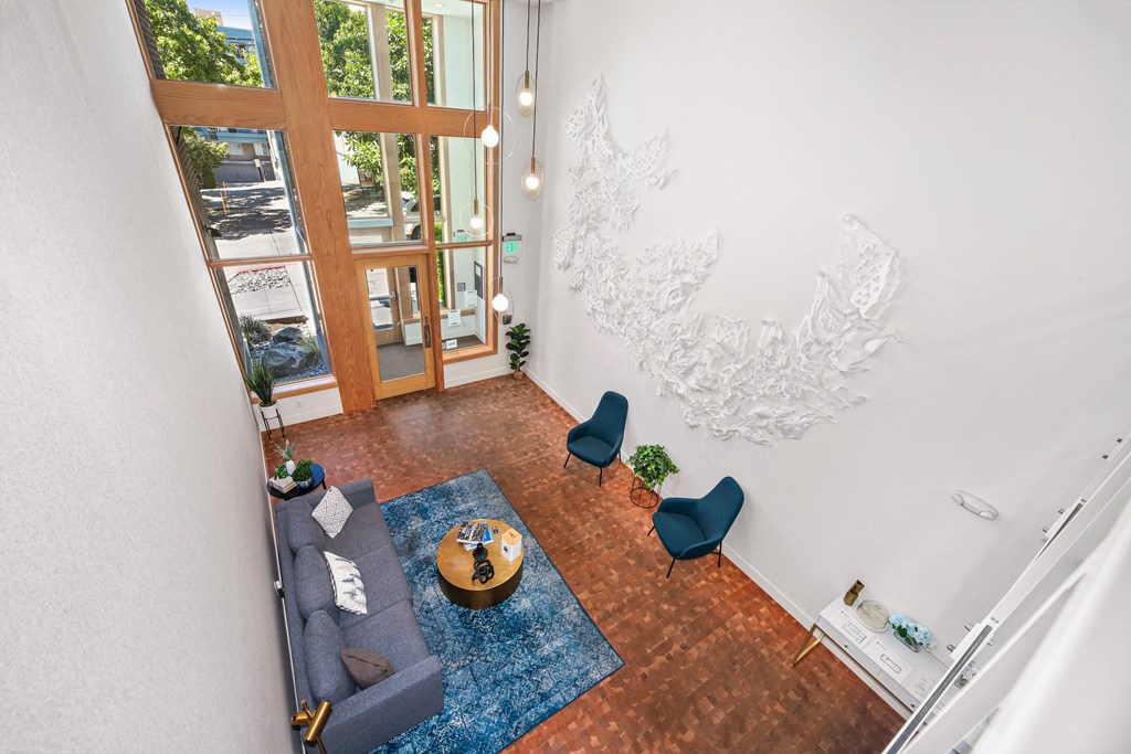 an aerial view of a living room with a couch and chairs and a large window