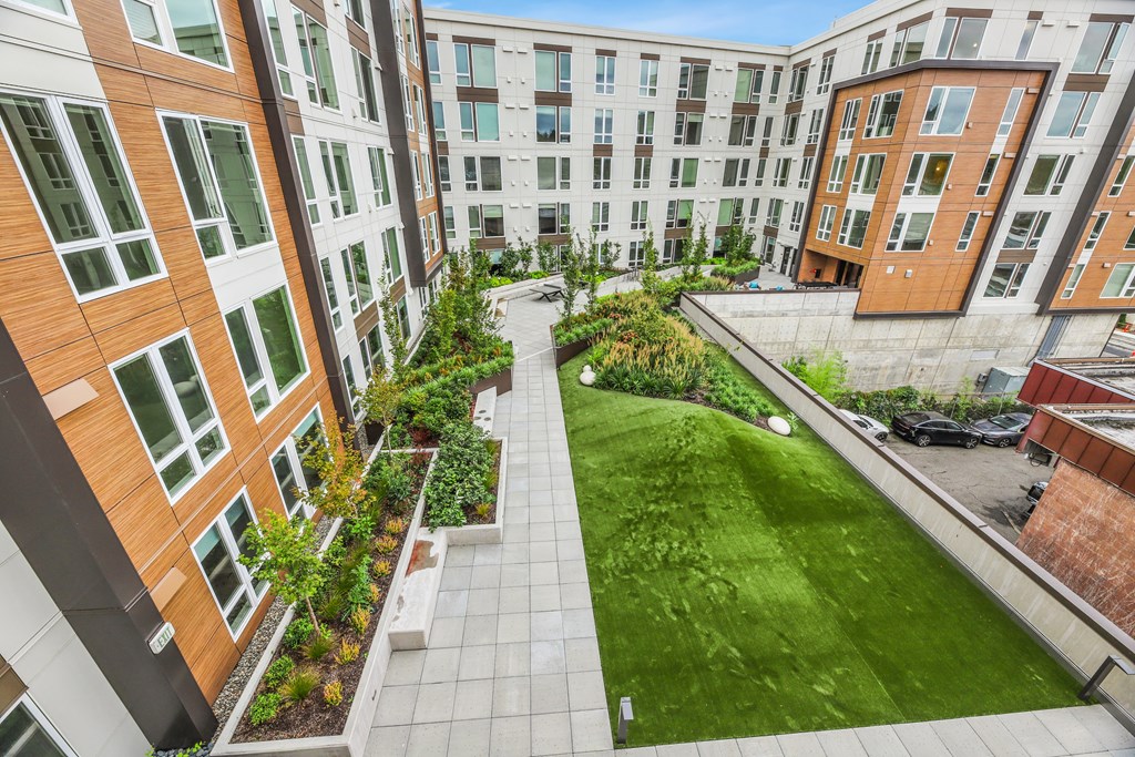 an aerial view of a courtyard with green grass and buildings