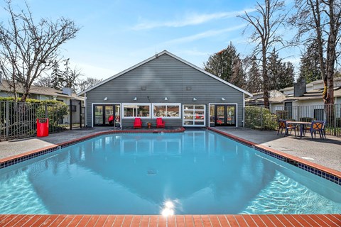 A swimming pool in front of a grey building.