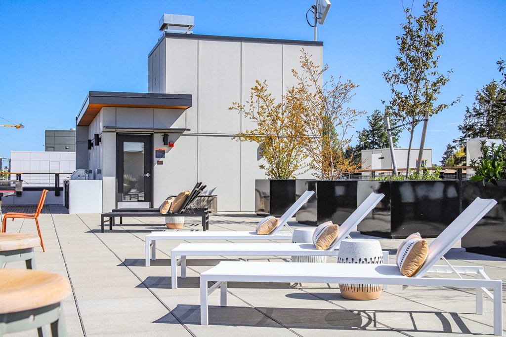 a patio with tables and chairs and a building in the background