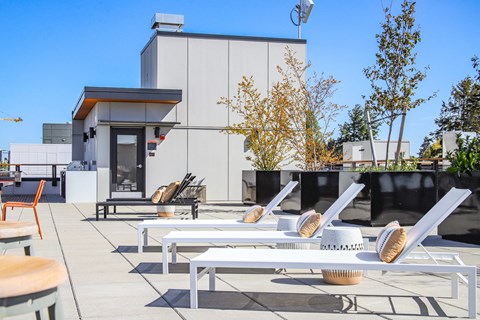 a patio with tables and chairs and a building in the background