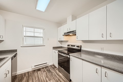 A kitchen with white cabinets and a black stove top oven.