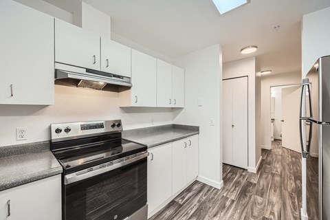 A kitchen with white cabinets and a black stove top oven.