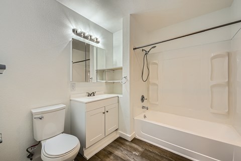 A white bathroom with a toilet, sink, and bathtub.