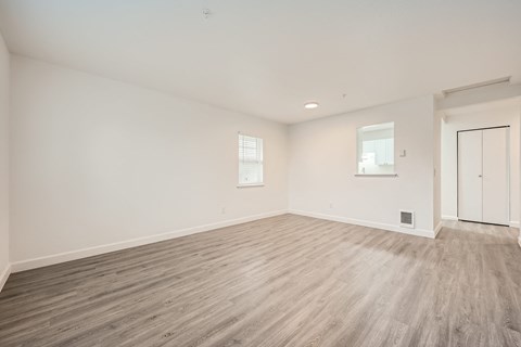 A room with wooden flooring and white walls.