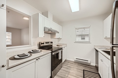 A kitchen with white cabinets and appliances.