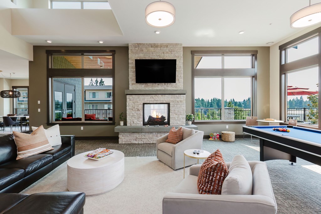 A modern living room with a pool table and a fireplace.