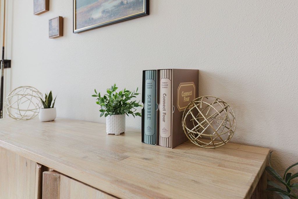 A wooden shelf with a plant, a book, and a decorative ball.