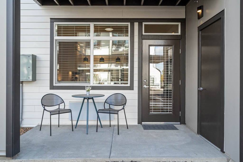 a patio with a table and chairs and a door