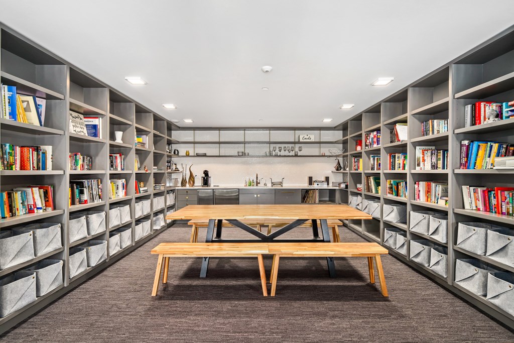 a library with shelves filled with books and a table