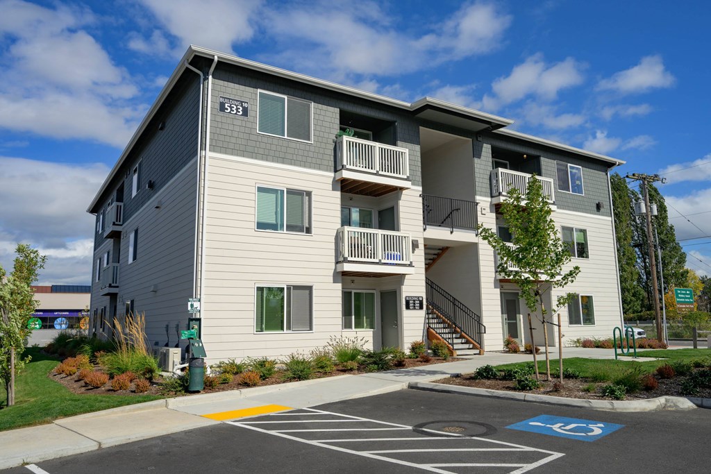 Apartment building with a parking lot in front.