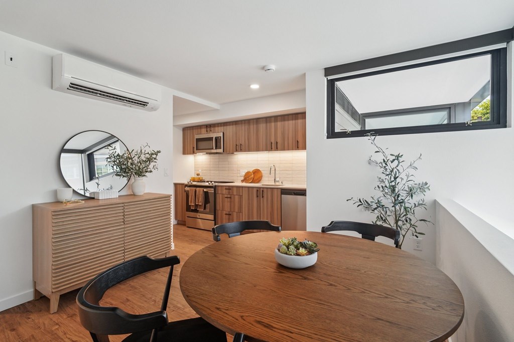 A modern dining room with a round wooden table and chairs.