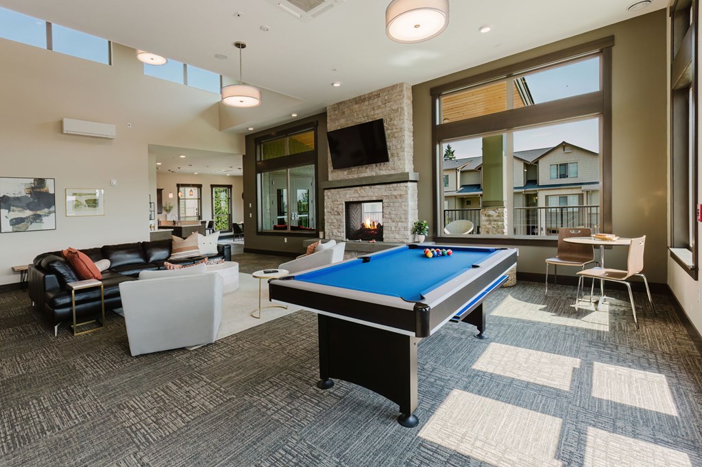 A billiard table is in the middle of a living room.