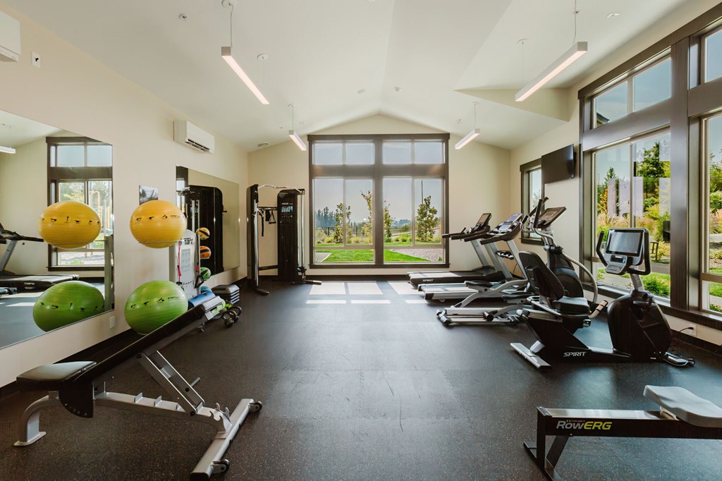 A gym with a variety of equipment including treadmills, exercise bikes, and weight racks.
